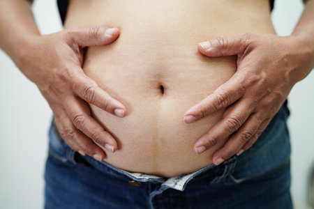 Asian woman show fat belly big size overweight and obesity at office.の写真素材