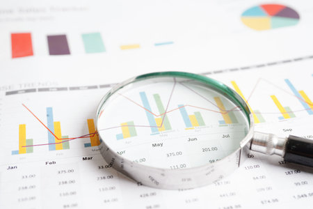 Magnifying glass on charts graphs paper. Financial development, Banking Account, Statistics,...