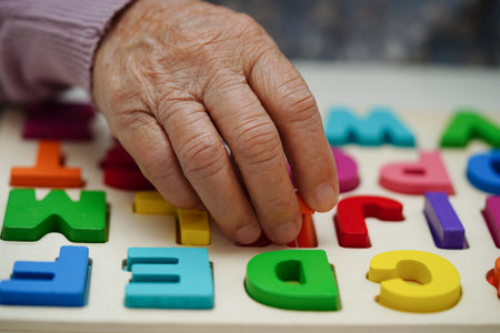 Asian elderly woman playing puzzles game to practice brain training for dementia prevention, Alzheimer disease.の写真素材