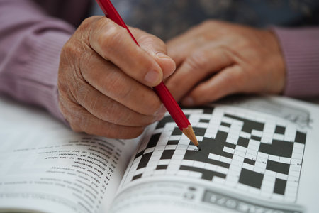 Asian elderly woman playing sudoku puzzle game to practice brain training for dementia prevention, Alzheimer disease.の写真素材