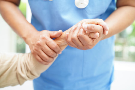 Doctor holding hands Asian elderly woman patient, help and care in hospital.の写真素材