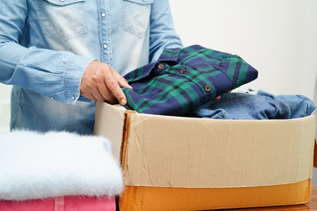 Clothes donations in cardboard box for volunteer.の写真素材