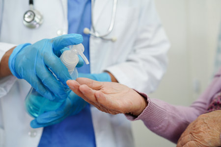 Asian senior woman press blue alcohol sanitizer gel for washing hand protect infection coronavirus.の写真素材