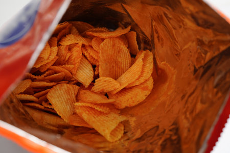 Potato chips in open bag, delicious BBQ seasoning spicy for crips, thin slice deep fried snack fast food.の写真素材
