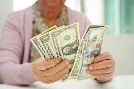 Retired elderly woman counting coins money and worry about monthly expenses and treatment fee payment.の写真素材