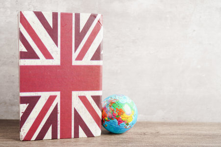 Bangkok, Thailand April 1, 2023 English book and piggy bank with globe, learning and tutorial for foreigner.のeditorial素材