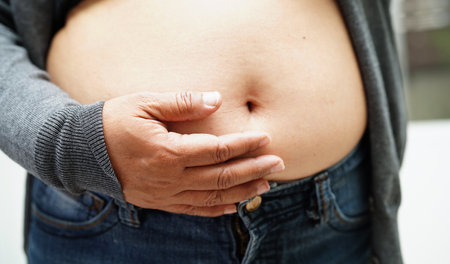 Asian woman show fat belly big size overweight and obesity at office.の写真素材