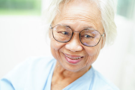Asian senior woman wearing eyeglasses or vision glasses at home care service.の写真素材