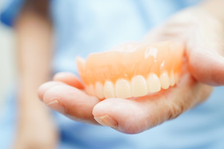 Doctor holding teeth denture in hand for dentist studying about dentistry.の写真素材