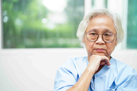 Asian senior woman wearing eyeglasses or vision glasses at home care service.の写真素材