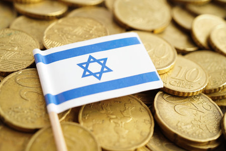 Israel flag on coins background, finance and accounting, banking concept.の写真素材