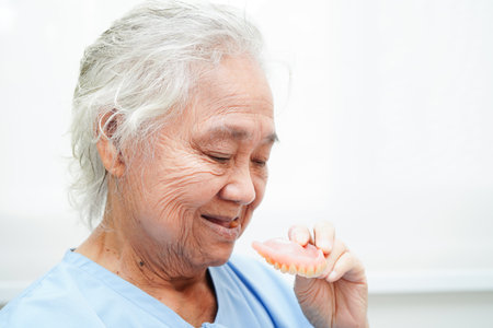 Doctor holding teeth denture in hand for dentist studying about dentistry.の写真素材