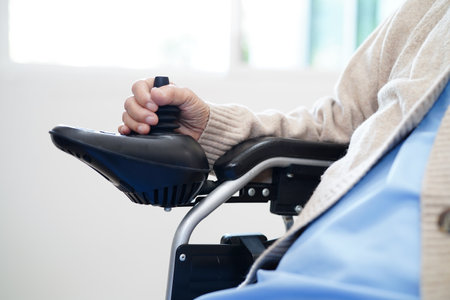 Asian elderly disability woman patient use joystick electric wheelchair in hospital.の写真素材