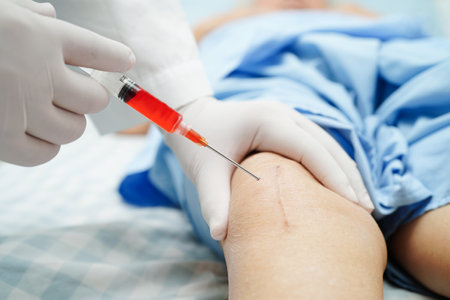 Asian doctor inject Hyaluronic acid platelet rich plasma into the knee of senior woman to walk...