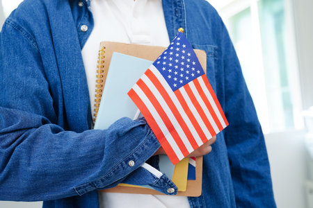 Learning English, Asian teenage student holding book with flag for language program education.の写真素材