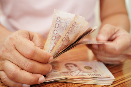 Asian woman counting Thai baht banknote money and holding in hand, investment economy, accounting...