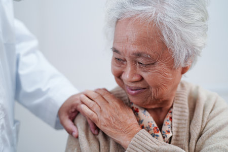Asian doctor touching patient to support, consolation encourage and help support health care medical.の写真素材