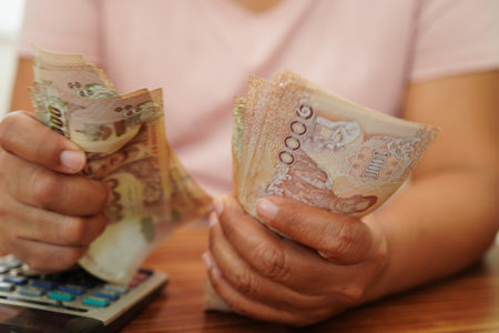 Asian woman counting Thai baht banknote money and holding in hand, investment economy, accounting business and banking.の写真素材