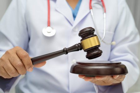 Asian doctor holding court hammer for and crime law justice, forensic medicine.の写真素材