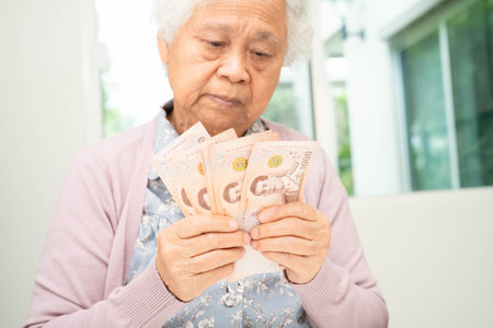Retired elderly woman counting coins money and worry about monthly expenses and treatment fee...
