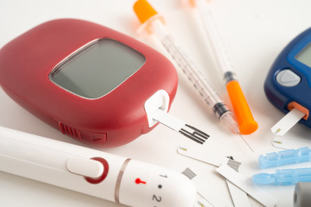 Glucometer lancet and test stick measuring human blood sugar level for diabetes.の写真素材