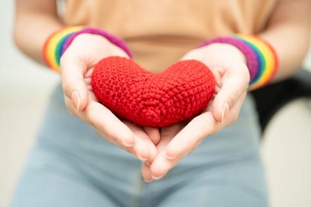 Asian woman holding LGBT heart with rainbow flag.の写真素材