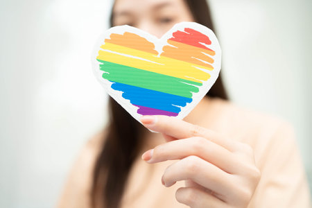 Asian woman holding LGBT heart with rainbow flag.の写真素材