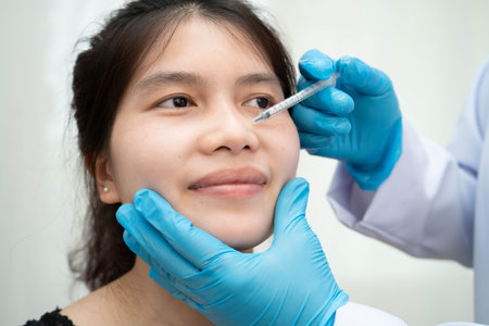 Asian woman receiving lip contouring procedure augmentation performed on face.の写真素材