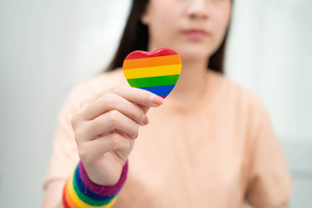 Asian woman holding LGBT heart with rainbow flag.の写真素材