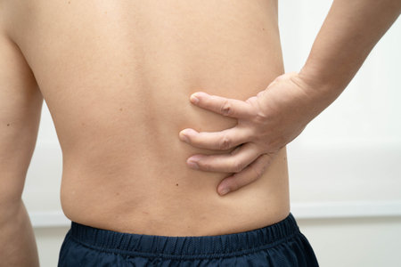 Asian man pain back muscle, spine and bone from accident.の写真素材