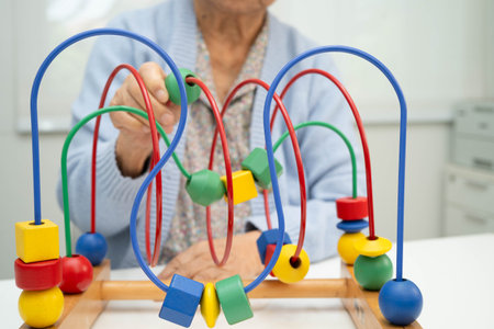 Asian elderly woman playing enhancing skill board game.の写真素材