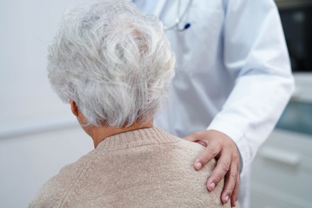 Doctor taking care, help and encourage Asian elder senior woman patient in clinic hospital.の写真素材
