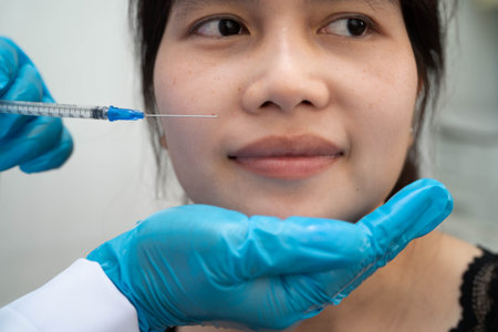 Asian woman receiving filler face beauty injection.の写真素材