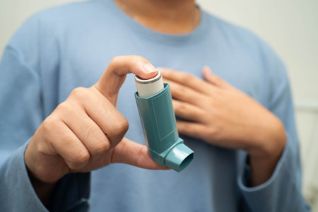 Asthma and chronic obstructive pulmonary disease COPD, Asian young man using metered dose inhaler...