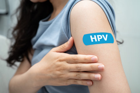 HPV, Human papillomavirus, Asian young woman receiving vaccine with blue bandage.