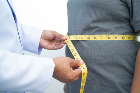Asian woman with fat belly big size overweight and obesity with measure tape.
