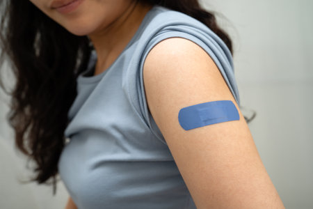 HPV, Human papillomavirus, Asian young woman receiving vaccine with blue bandage.