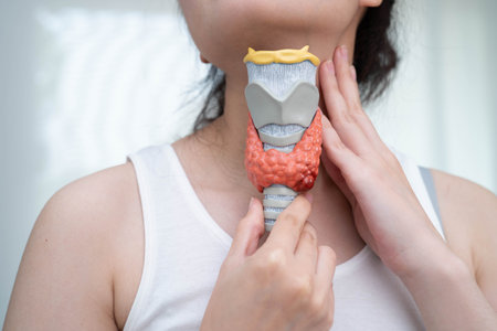 Asian woman with thyroid gland human anatomy model.