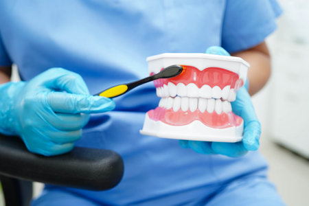Doctor clean teeth denture with toothbrush for teach patient and dentist studying about dentistry.