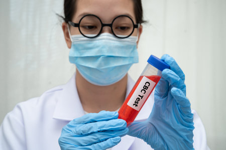 Scientist medical professional holding Cholesterol CBC test tube blood for research in science laboratory.の写真素材
