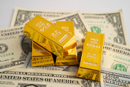 Gold bars on US dollar banknote money, finance trading investment business currency concept.の写真素材