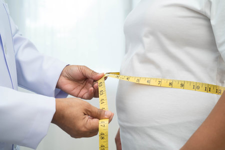 Asian woman with fat belly, big size, overweight, and obesity, with measure tape.の写真素材