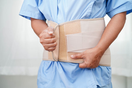 Asian senior wearing elastic support belt can help reduce back pain.