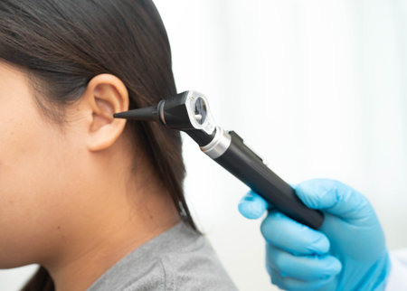 Otolaryngologist or ENT physician doctor examining patient ear with otoscope.の写真素材