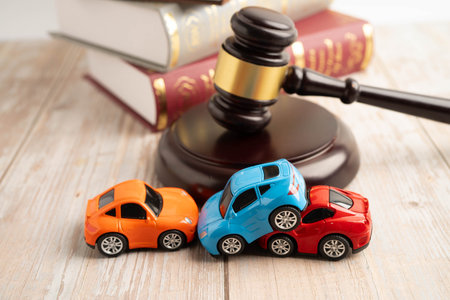 Bangkok, Thailand March 15, 2024 Car accident lawsuit and insurance, Judge hammer and money with car model.のeditorial素材