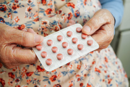 Asian elderly woman holding pill in hand, strong healthy medical.