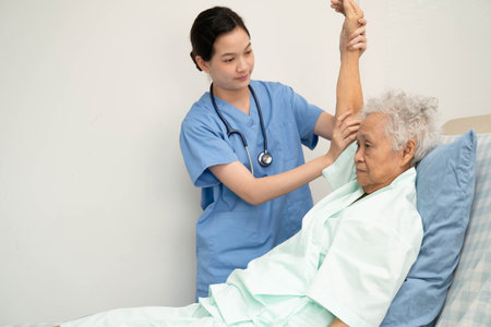 Asian doctor checking and treating elderly woman patient health in hospital.