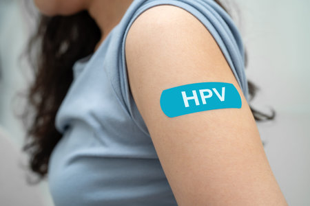 HPV, Human papillomavirus, Asian young woman receiving vaccine with blue bandage.