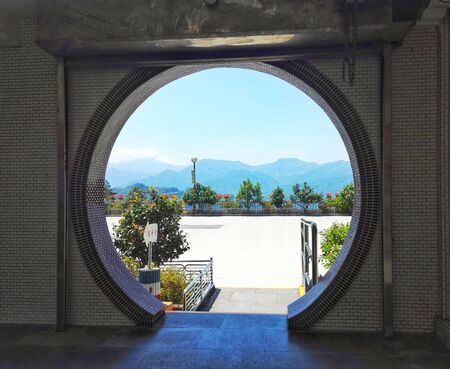 Scenic Chinese round gate, view over mountain range in backgroundの写真素材