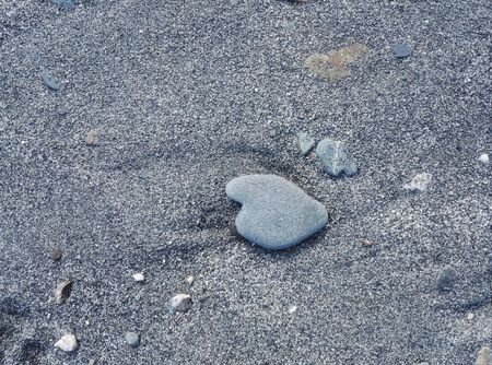 Natural heart shape stone in sandの写真素材